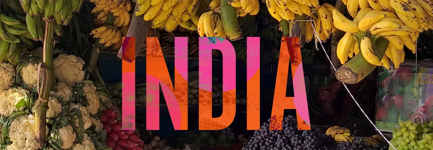 Indian fruit stand with bananas, cauliflower and grapes.